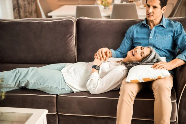 Felice donna adulta sdraiata sul divano a casa — Foto Stock