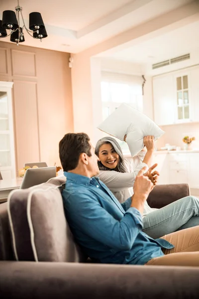 Adult man and woman having fun in living room at home