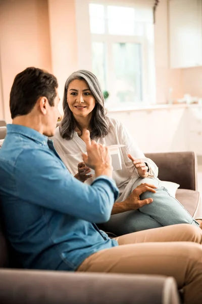 Homem adulto dando presente para mulher bonita em casa — Fotografia de Stock