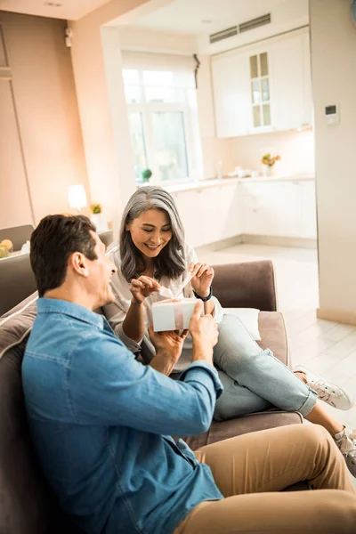 Sorridente donna adulta che tiene il nastro sulla scatola a casa — Foto Stock