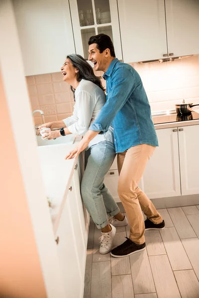 Boldog pár szórakozik, miközben a konyhában állnak. — Stock Fotó