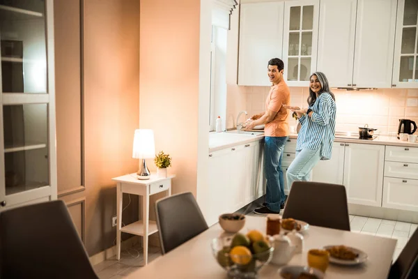 Glückliche hübsche Frau tanzt neben ihrem Mann in der Küche — Stockfoto