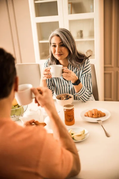 Boldog gyönyörű nő kezében tea, miközben nézi a férfi — Stock Fotó