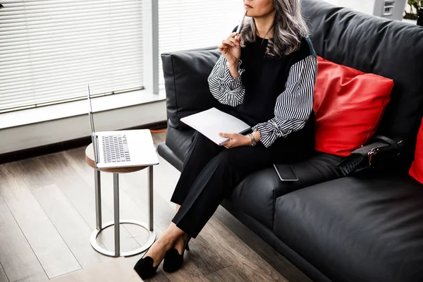 Tänksam kvinna med anteckningar i kontorslobbyn stockfoto — Stockfoto