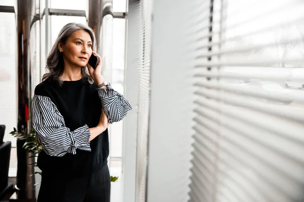 Schöne Dame telefoniert in ihrem Büro Archivfoto — Stockfoto