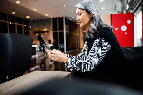 Pleased woman reading messages and smiling stock photo — Stock Photo, Image