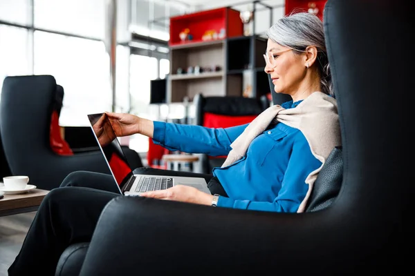Kvinnan öppnar laptopen och börjar sin arbetsdag lagerfoto — Stockfoto