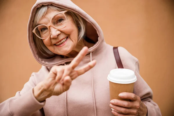 Feliz anciana mostrando V signo de stock foto — Foto de Stock