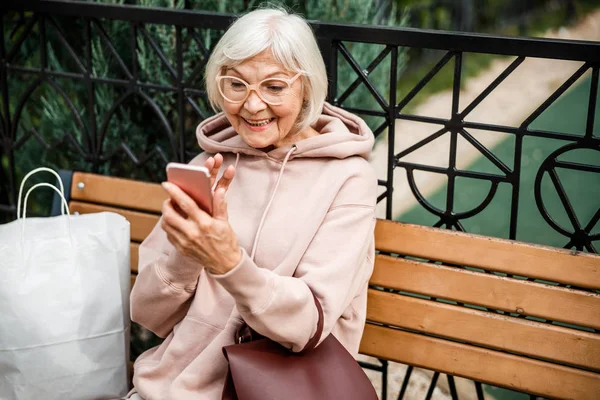 Mujer madura alegre haciendo videollamada al aire libre stock foto — Foto de Stock