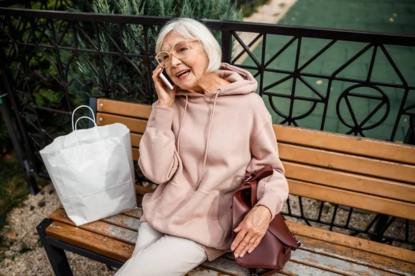 Rilassato vecchia signora parlando al telefono all'aperto stock foto — Foto Stock