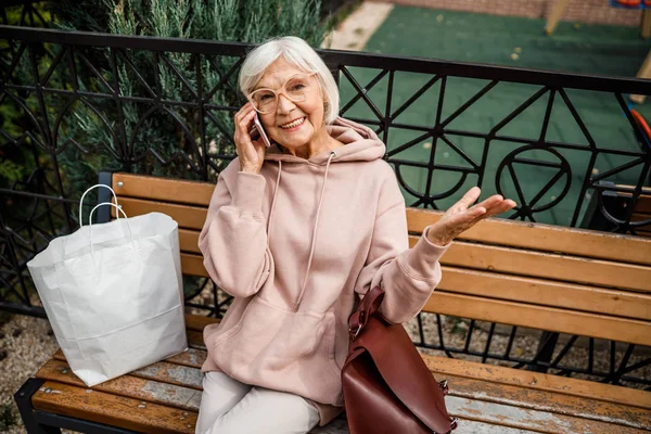 Счастливая зрелая женщина разговаривает по телефону на открытом воздухе фото — стоковое фото