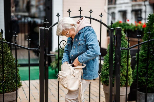 Зрелая женщина ищет ключ в сумке фото запас — стоковое фото