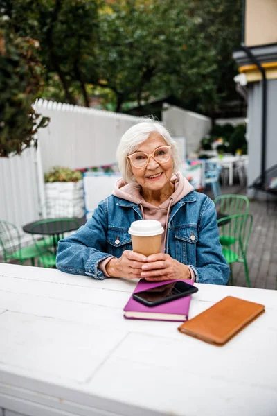 Feliz anciana disfrutando del café en la cafetería al aire libre foto de stock — Foto de Stock