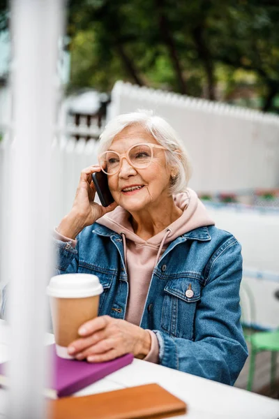 Sonriente abuela con café haciendo llamada foto de stock — Foto de Stock