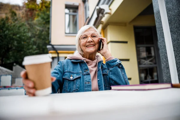 Vrolijke senioren dame praten aan de telefoon met koffie stock foto — Stockfoto