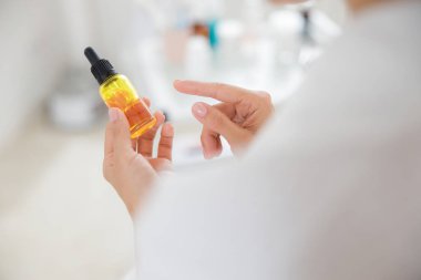 Ellerinde vitamin serumu olan genç bir kadın.