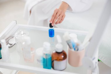 Bir şişe vitamin serumu alan genç bir kadın.