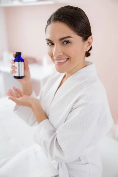 Okouzlující mladá žena drží láhev vitamínového séra — Stock fotografie