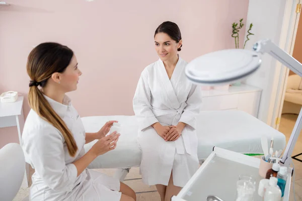 Cosmetólogo discutiendo vitaminas con la joven sonriente — Foto de Stock