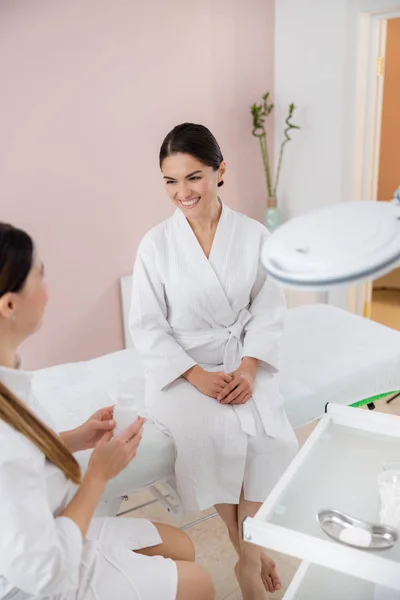 Cheerful young woman talking with beautician at spa salon — 스톡 사진