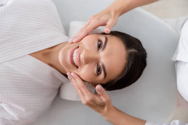 Masajista manos masaje cara de alegre dama — Foto de Stock