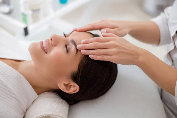 Jovem encantadora desfrutando de massagem facial no salão de beleza — Fotografia de Stock