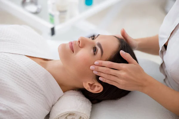 Atractiva joven mujer teniendo masaje facial en el salón de belleza — Foto de Stock