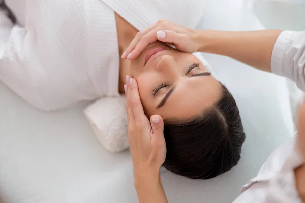 Relaxado jovem mulher tendo massagem facial no salão de beleza — Fotografia de Stock