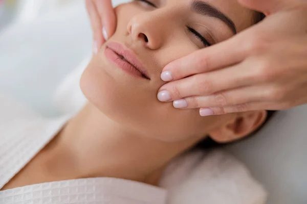Młoda dama ma masaż twarzy w salonie spa — Zdjęcie stockowe