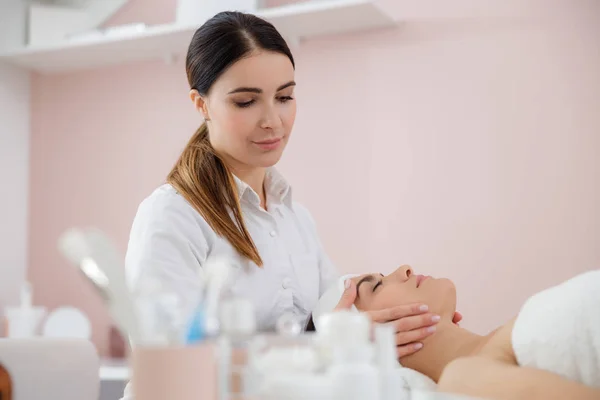 Massaggiatrice professionista massaggio viso di giovane donna — Foto Stock