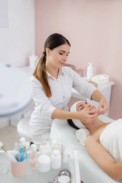 Encantadora joven que tiene masaje facial en el salón de belleza — Foto de Stock