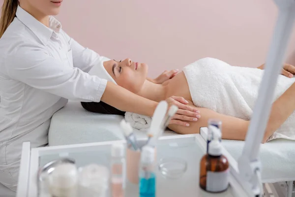 Mooie jonge vrouw met massage op spa salon — Stockfoto