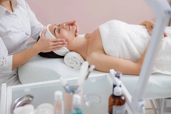 Señora relajada disfrutando de masaje facial en el salón de spa — Foto de Stock