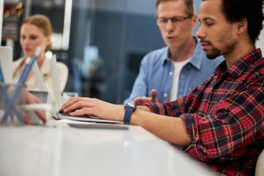 İş arkadaşlarıyla yeni bir proje üzerinde çalışan Afro-Amerikalı adam.