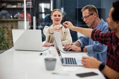 Meslektaşına kalem uzatan güzel bir genç kadın.