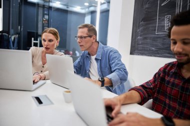 Modern ofiste dizüstü bilgisayar kullanan iş arkadaşları