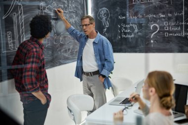 İş arkadaşları modern ofiste projeyi tartışıyor