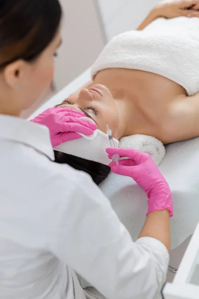 Relaxado jovem recebendo injeções de beleza no salão de spa — Fotografia de Stock