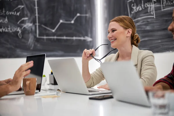 Gioiosa bella signora seduta a tavola in ufficio — Foto Stock