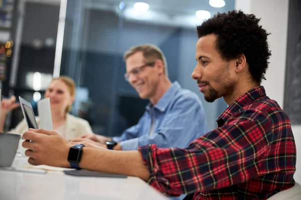 Glimlachende afro-Amerikaanse man werkt met collega 's in het kantoor — Stockfoto