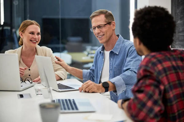 Equipo creativo que se comunica y ríe en la oficina — Foto de Stock