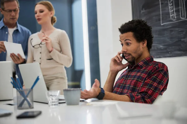 Афроамериканець розмовляє по телефону на роботі — стокове фото
