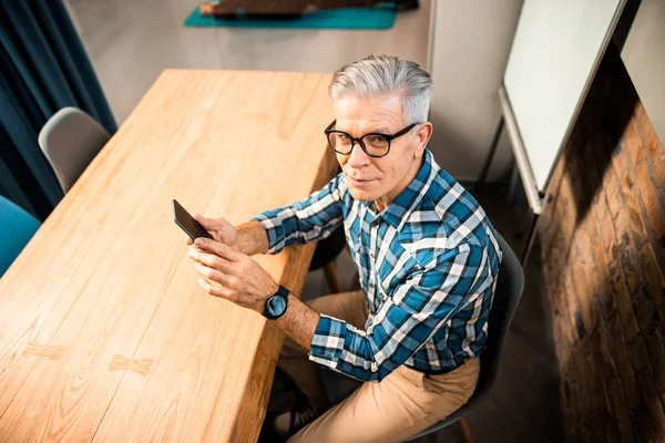 Happy adult man with smartwatch sitting at workplace — Stock Photo, Image