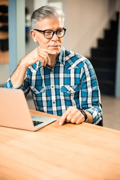 Mature male in glasses looking away indoors — Stock Photo, Image