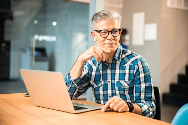 Le mogen man sitter vid bordet med gadget — Stockfoto