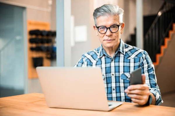 Smiling mature male looking at camera at workplace — Stock Photo, Image