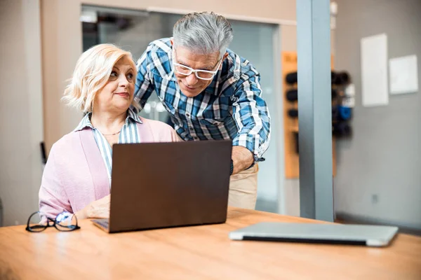 Glimlachen volwassen man helpen mooi vrouw met gadget — Stockfoto