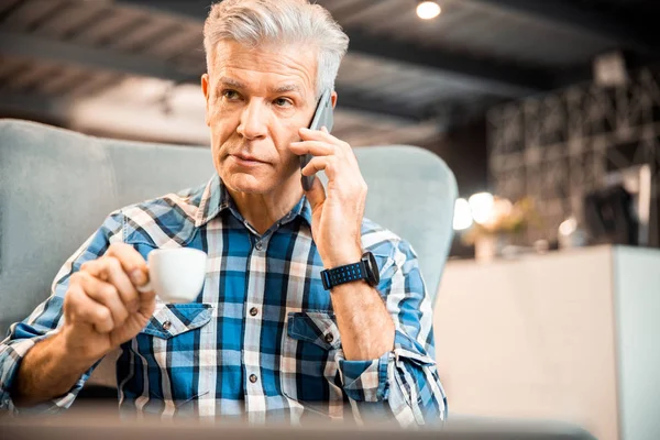 Adult man is talking on mobile phone in cafe — Stock Photo, Image