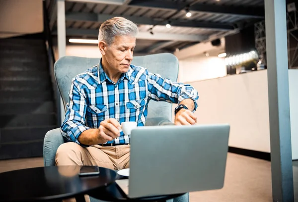 Adult man is checking the time in cafe — Stock Photo, Image