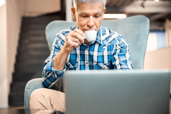 Volwassen man drinkt koffie in café — Stockfoto